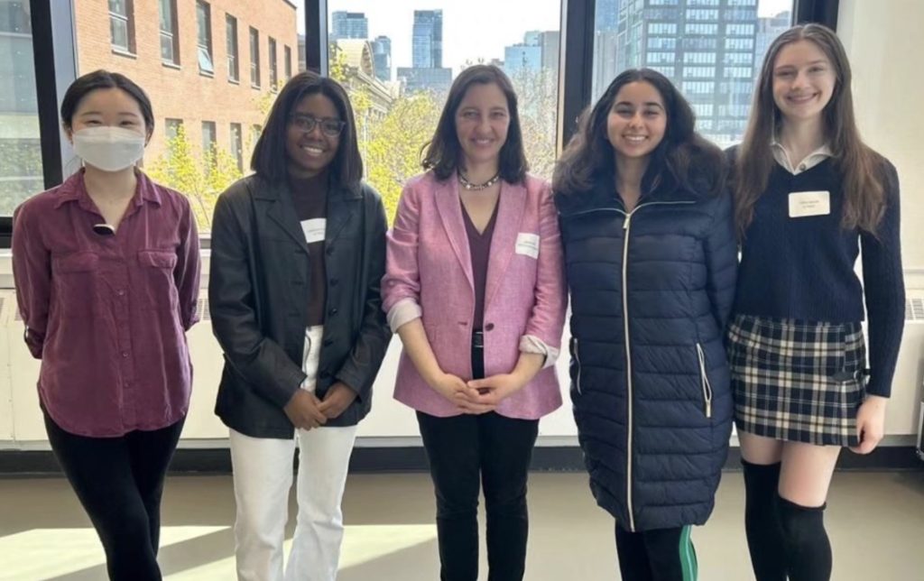 Five students, including Catherine, standing and smiling during a U-TAAC event.
